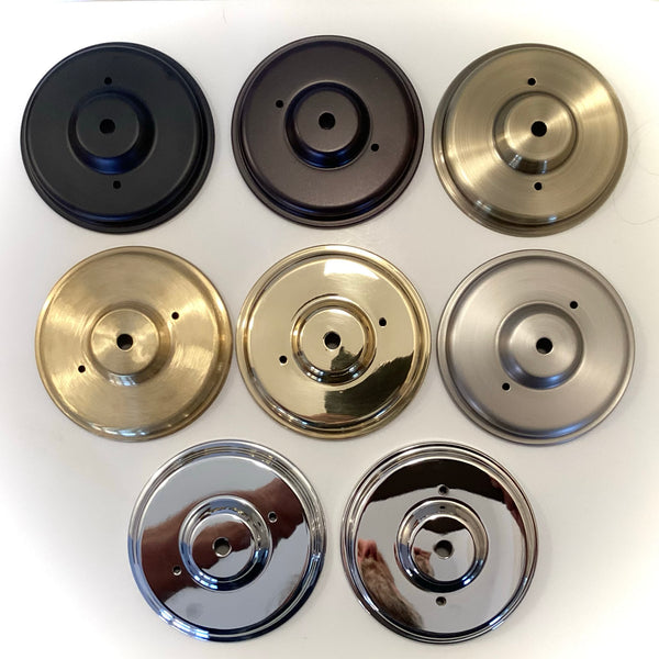 Assorted round metal ceiling canopies in multiple finishes—including black, oil-rubbed bronze, antique brass, polished brass, satin nickel, chrome, and polished nickel—displayed for lighting restoration at Vintporium.