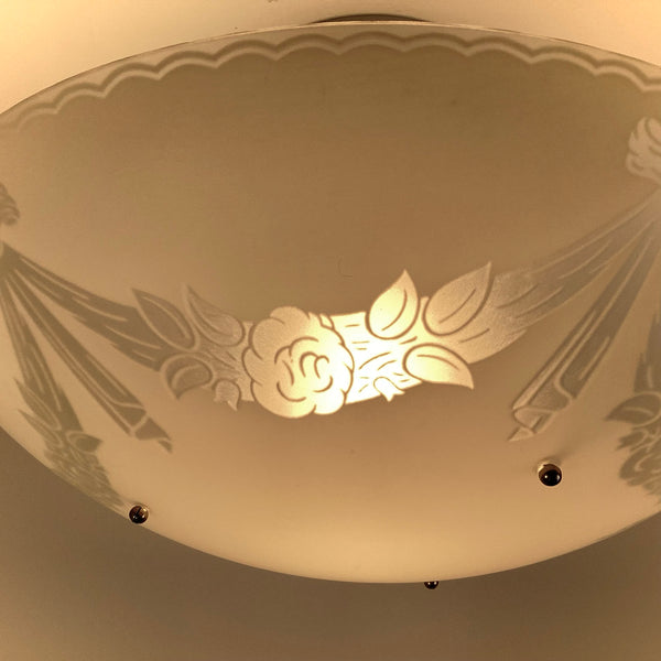 Close-up of enameled floral detail on a vintage 1950s semi-flush ceiling light