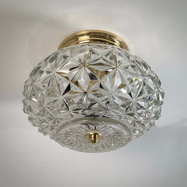 Vintage mid-century crystal flush mount ceiling light fixture featuring a faceted diamond starburst glass shade and polished brass canopy, viewed from below — Vintporium.