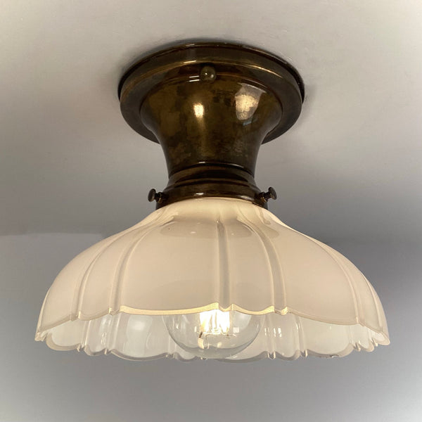 Art deco brass flush mount ceiling light with milk glass shade side view