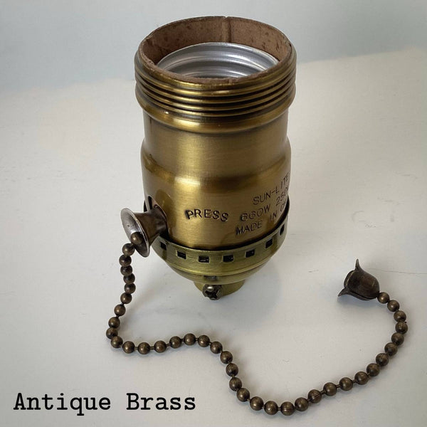 Antique brass UNO pull-chain socket with aged patina and matching chain.
