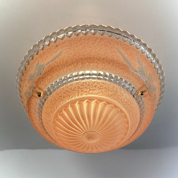 Underside view of peach floral etched glass flush mount ceiling light, centered