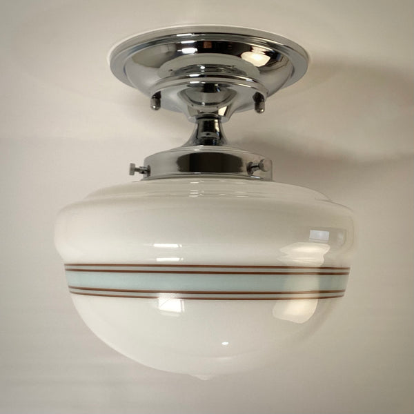 Mid-century style semi-flush mount light with chrome hardware and striped glass, bright white light.