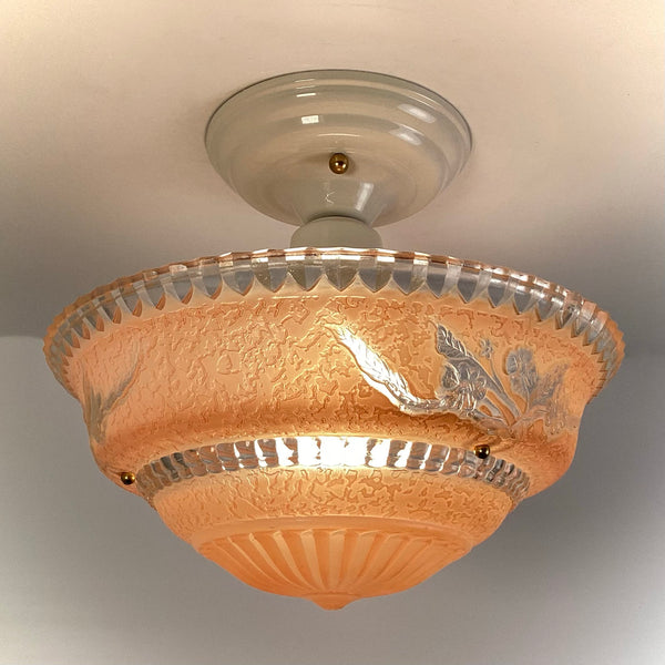 Illuminated peach floral etched glass ceiling light showing warm glow