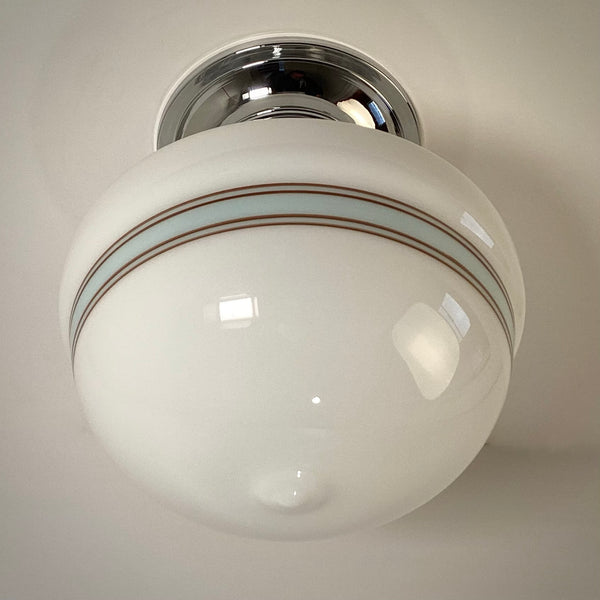 Spherical globe flush mount light fixture with chrome finish and striped opal glass, cool white light.
