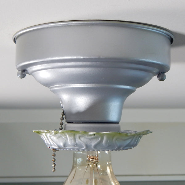The restored flush mount fixture has a new glazed porcelain pull chain socket, wires, and a silver and green two-tone enamel paint finish. The fixture has been cleaned and detailed and has mounting hardware for convenient installation. Available at www.vintporium.com