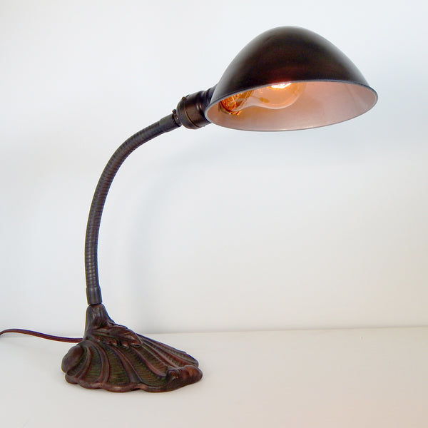 The antique lamp's steel shade has been painted to match the patina bronze base. The interior shade features a silver-painted finish. The has been restored with new wires, socket guts, etc. Available at www.vintporium.com