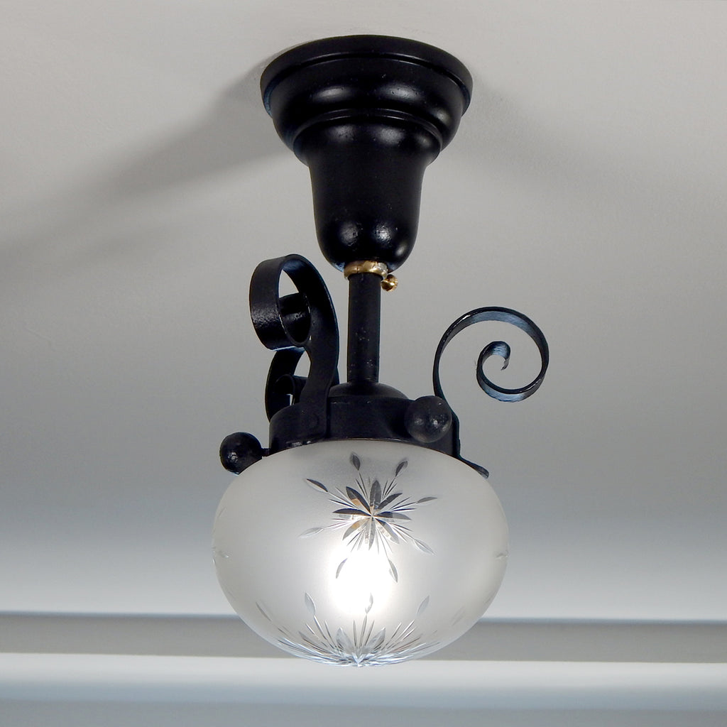 Approximately from the 1900s to the 1920s, this antique hand-crafted iron ceiling light fixture offers a superb blend of artistic impact and practicality. The semi-flush mount design of the fixture ensures that the fixture remains close enough to the ceiling to maintain an intimate ambiance while providing ample illumination to light any room with a gentle, inviting glow. Available at www.vintporium.com