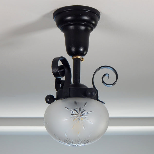 Approximately from the 1900s to the 1920s, this antique hand-crafted iron ceiling light fixture offers a superb blend of artistic impact and practicality. The semi-flush mount design of the fixture ensures that the fixture remains close enough to the ceiling to maintain an intimate ambiance while providing ample illumination to light any room with a gentle, inviting glow. Available at www.vintporium.com