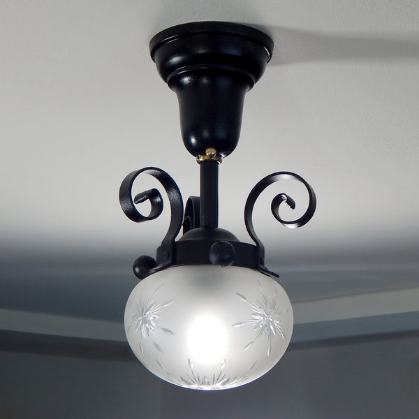 Approximately from the 1900s to the 1920s, this antique hand-crafted iron ceiling light fixture offers a superb blend of artistic impact and practicality. The semi-flush mount design of the fixture ensures that the fixture remains close enough to the ceiling to maintain an intimate ambiance while providing ample illumination to light any room with a gentle, inviting glow. Available at www.vintporium.com