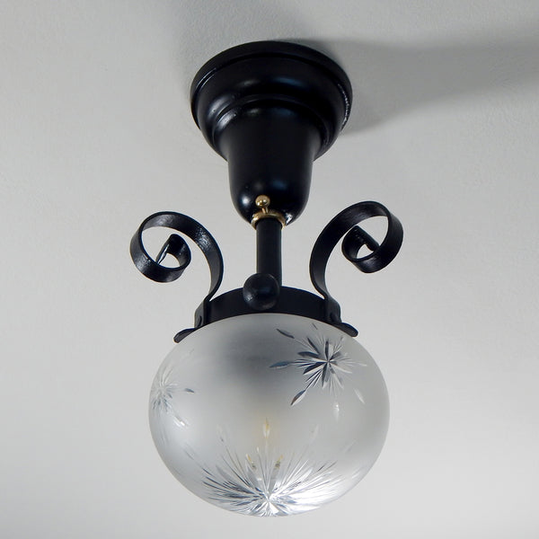 Approximately from the 1900s to the 1920s, this antique hand-crafted iron ceiling light fixture offers a superb blend of artistic impact and practicality. The semi-flush mount design of the fixture ensures that the fixture remains close enough to the ceiling to maintain an intimate ambiance while providing ample illumination to light any room with a gentle, inviting glow. Available at www.vintporium.com