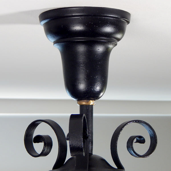 Approximately from the 1900s to the 1920s, this antique hand-crafted iron ceiling light fixture offers a superb blend of artistic impact and practicality. The semi-flush mount design of the fixture ensures that the fixture remains close enough to the ceiling to maintain an intimate ambiance while providing ample illumination to light any room with a gentle, inviting glow. Available at www.vintporium.com