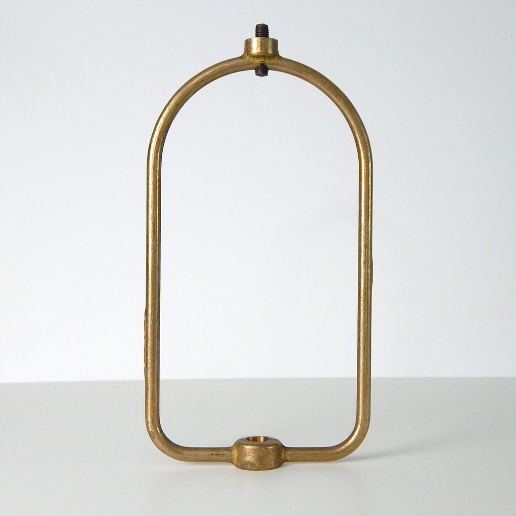 This harp is the most versatile center-post shade holder available on the market. It is designed to fit glass shades with either a 1/8 IPS center hole or a smaller 1/4-27 thread. The harp can be used for boudoir lamps or ceiling center-post light fixtures. The harp supports the shade and usually mounts under the socket and socket cup to the ceiling canopy or lamp base. The harp is unfinished brass. Available at www.vintporium
