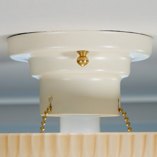 The semi-flush triple-beaded chain ceiling light fixture emerged with its earliest iterations in the 1920s through the 1940s. Triple-beaded chain fixtures of this period featured bold patterns and almost always had enameled finishes in pinks, blues, greens, whites, or bisque colors. The trend continued into the 1960s with less heavy-looking glass shades and silk-screened enameled finishes instead of the hand-painted enameled finish. Available at www.vintporium.com