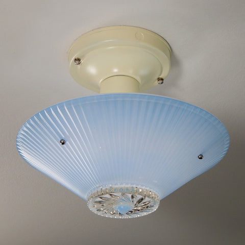 The semi-flush triple-beaded chain ceiling light fixture emerged with its earliest iterations in the 1920s through the 1940s. Triple-beaded chain fixtures of this period featured bold patterns and almost always had enameled finishes in pinks, blues, greens, whites, or bisque colors. The trend continued into the 1960s with less heavy-looking glass shades and silk-screened enameled finishes instead of the hand-painted enameled finish. Available at www.vintporium.com