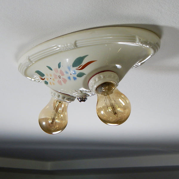 The vintage 1930s porcelain ceiling light has uranium glass glazed highlights and a delightful glazed floral stenciled pattern. The fixture has been restored and features new wiring and sockets, etc. The fixture has been cleaned, detailed, and is ready to install. Available at www.vintporium.com
