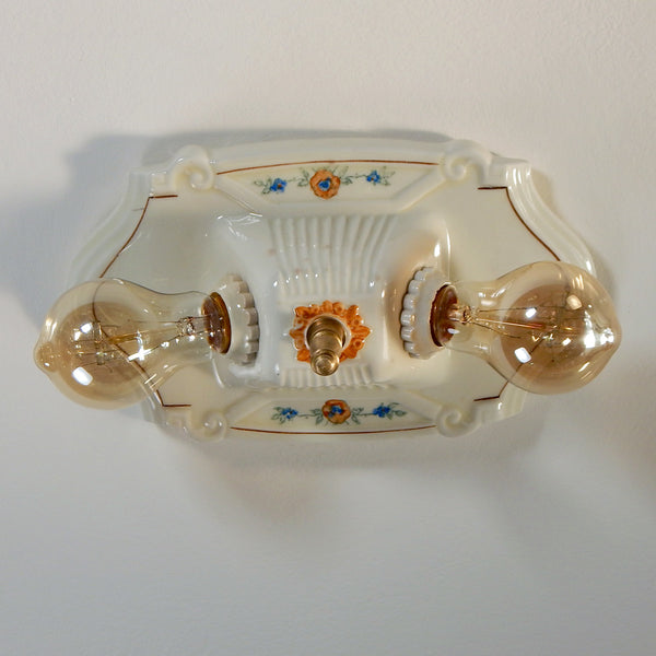 The vintage 1920's porcelain light fixture has been restored and features new wiring and sockets, etc. The fixture has been cleaned, detailed, and ready to install. Available at www.vintporium.com