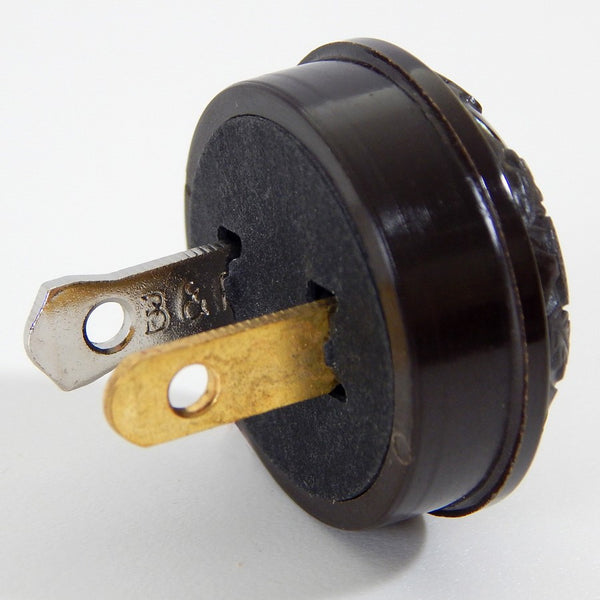 Early electric replica embossed acorn and oak leaf motif bakelite plug. The plug features an insulator and polarized prongs.  Available at www.vintporium.com
