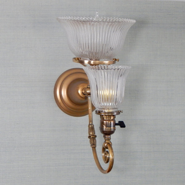 This renovated antique Victorian-era electric sconce has been rewired with numerous new parts added. Circa 1905ish, its naturally aged brass finish emphasizes its age and unique character. The fixture features new wiring, sockets, etc., and has been cleaned, yet not overly detailed. The sconce comes with mounting hardware making it convenient to install. Available at www.vintporium.com