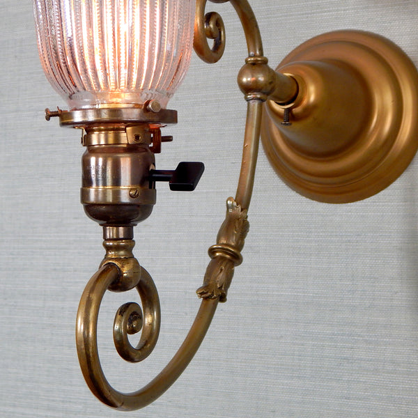 This renovated antique Victorian-era electric sconce has been rewired with numerous new parts added. Circa 1905ish, its naturally aged brass finish emphasizes its age and unique character. The fixture features new wiring, sockets, etc., and has been cleaned, yet not overly detailed. The sconce comes with mounting hardware making it convenient to install. Available at www.vintporium.com